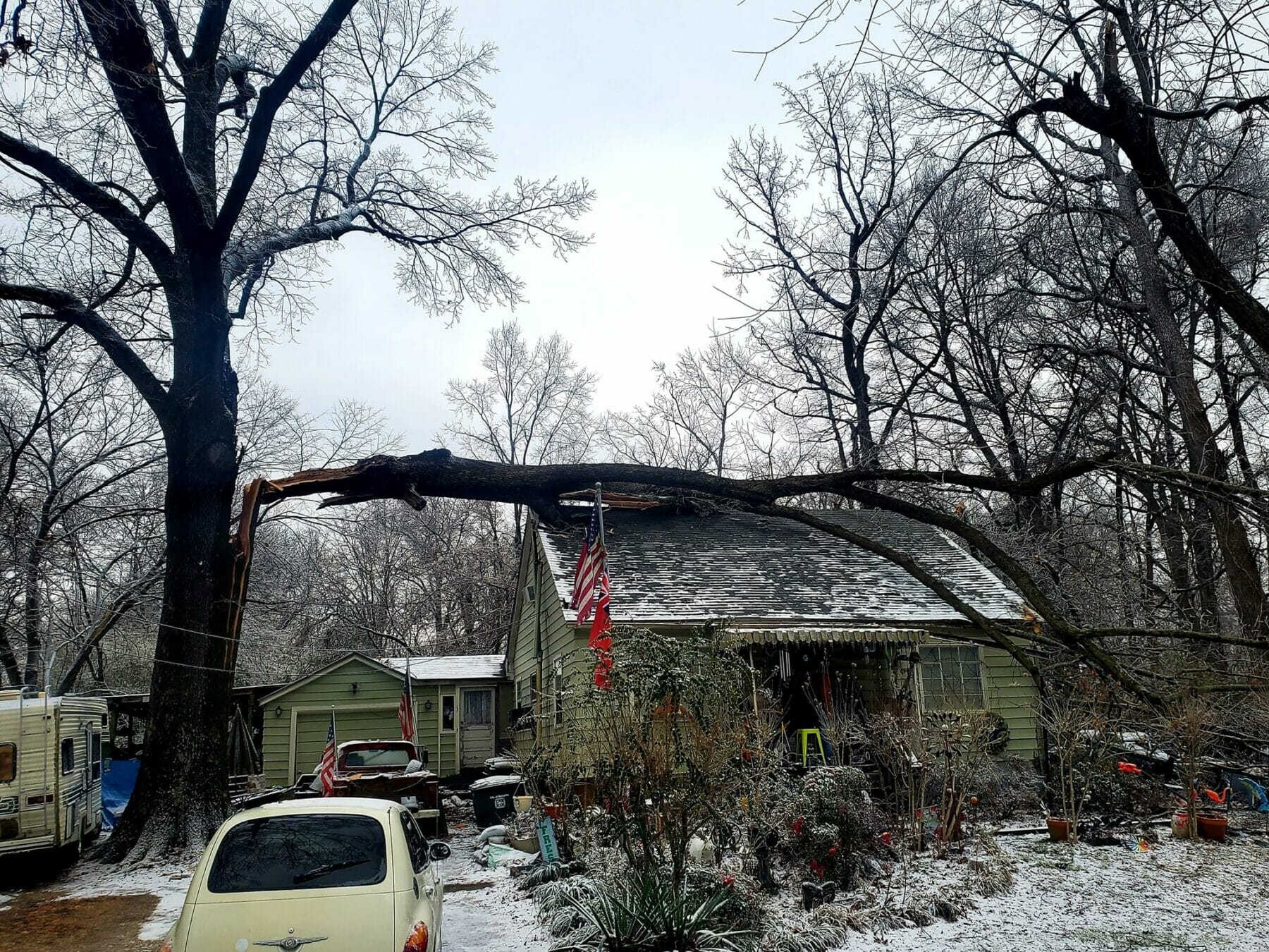 Large Portion of tree that has fallen and landed on roof of home